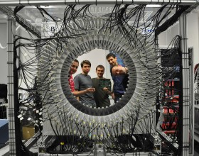 Czterech mężczyzn zaglądających do wnętrza urządzenia