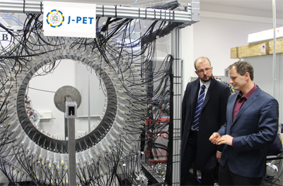 Profesor Moskal i Piotr Dardziński stojący obok wynalazku J-PET
